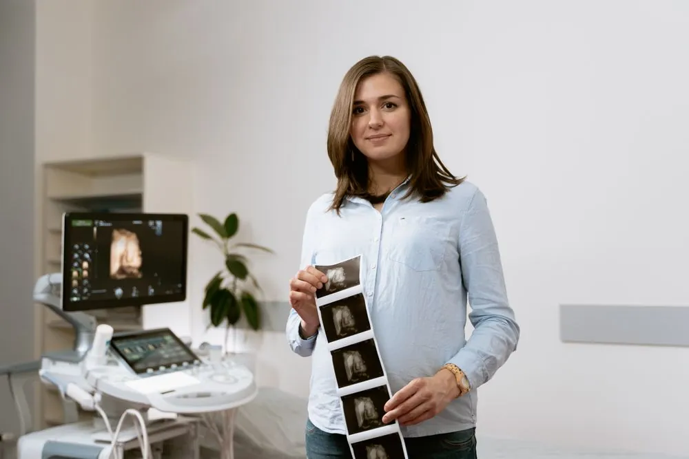 A woman holding printed ultrasound images